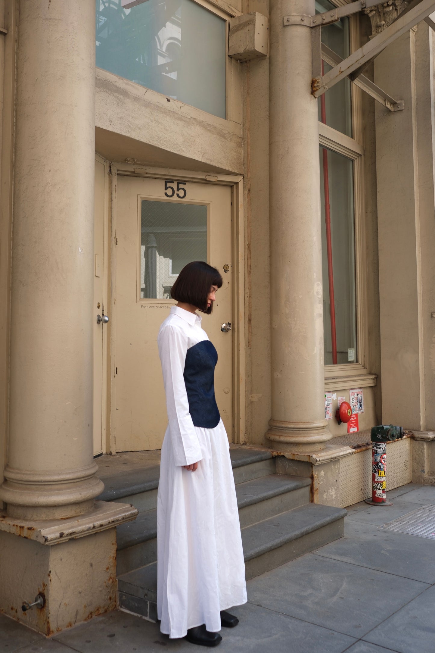 a white cotton maxi dress with a navy denim corset